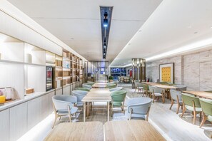 A modern interior with a central aisle, seating areas on both sides, and a vending machine. - JI Hotel (Hangzhou West Lake Hubin Jiefang Road) (Hangzhou)