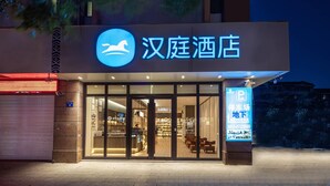 A hotel entrance with a signboard, glass doors, and a parking sign. - Hanting Express Rugao Anding Square (Nantong)