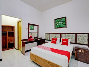 A hotel room with a bed, a desk, a wardrobe, and a bathroom. - OYO 90361 Griya Noumi Syariah (Surabaya)