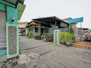 A restaurant with outdoor seating, a signboard, and a green awning. - OYO 90361 Griya Noumi Syariah (Surabaya)