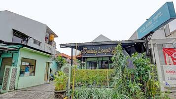 A building with a sign that reads 'Dining Langit' and another sign for 'GRIYA NOUMI HOTEL.'