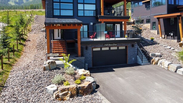 A modern two-story house with a garage, large windows, and a balcony. - Luxury. Steps to the Timberline Chairlift (Fernie)