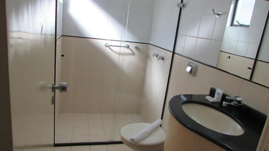 A bathroom with a shower, toilet, and sink.