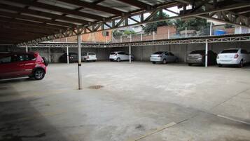 Un estacionamiento techado con varios coches aparcados.