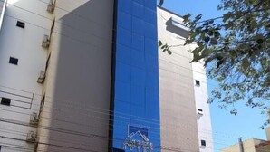 A hotel with a prominent blue facade and a sign that reads "Aspen Hotel". - Asppen (Chapecó)