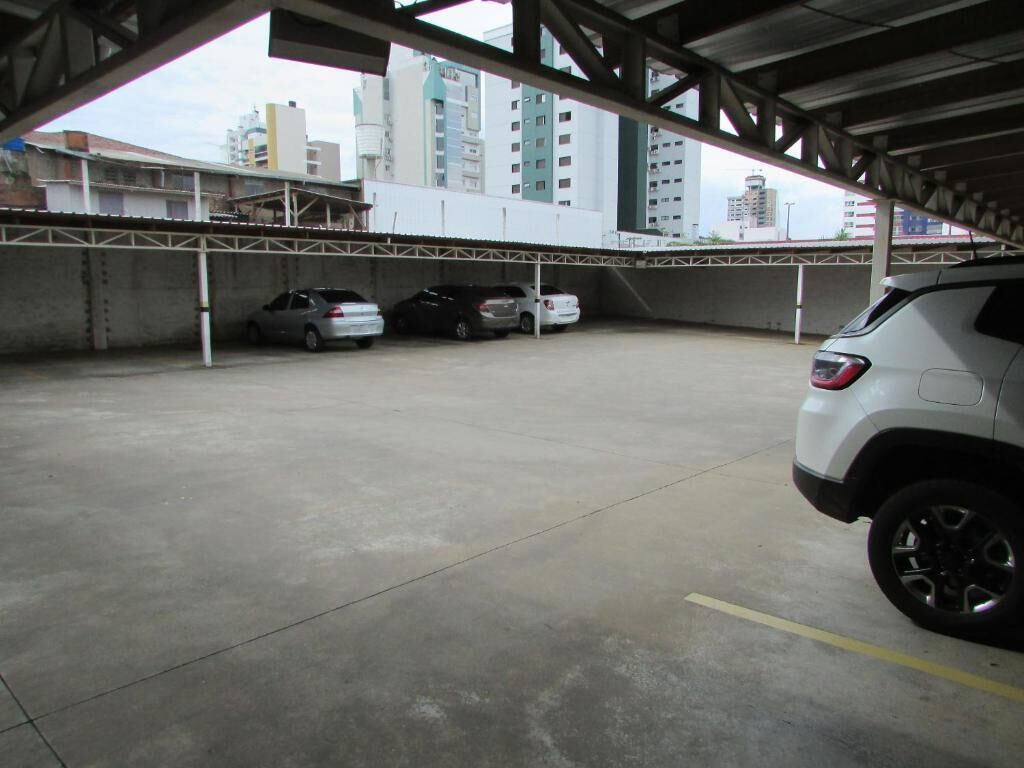 A parking garage with multiple cars parked under a covered area.