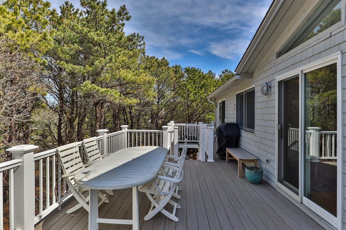 Une terrasse couverte avec une table et des chaises, un barbecue et un banc.