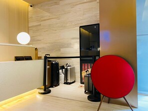 A reception area with a marble wall, a round light fixture, and a red chair. - JI Hotel Shanghai The Bund Jiujiang Road (Shanghai)
