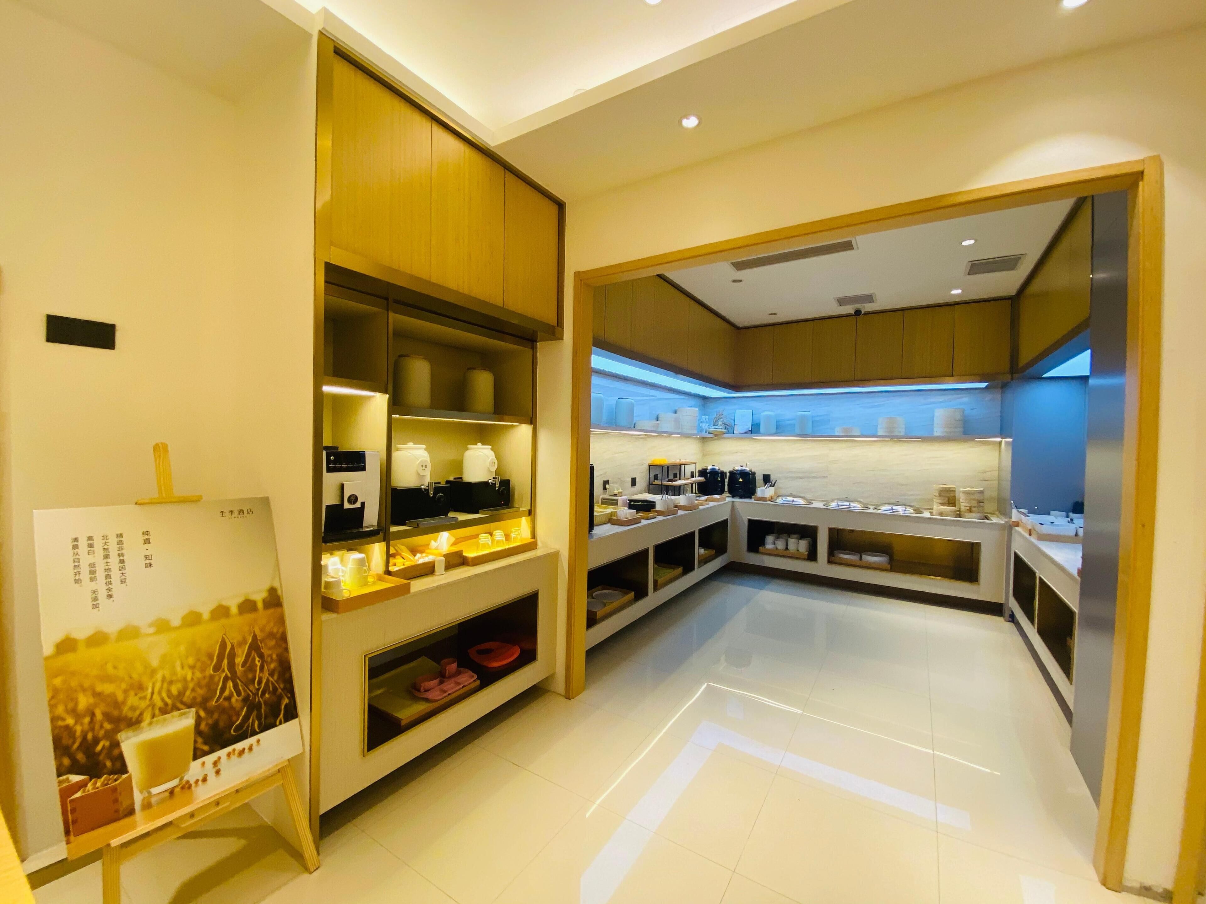Eine moderne Hotelküche mit übersichtlichem Design, ausgestattet mit verschiedenen Geräten und Stauraum für Lebensmittel und Getränke.