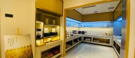 A modern hotel kitchen with a clean layout, equipped with various appliances and storage for food and beverages.