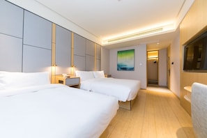 A hotel room with two beds, a nightstand, a painting, and a TV. - JI Hotel Shanghai The Bund Jiujiang Road (Shanghai)