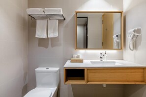 Un baño moderno con inodoro, lavamanos y toallero.