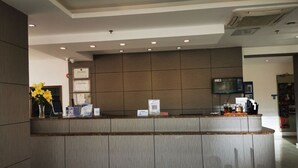 A reception desk with a digital screen, framed certificates, and a QR code. - Hanting Hotel (Shenzhen)