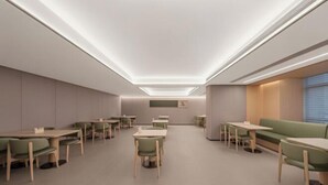 A modern dining area with tables and chairs, recessed ceiling lighting, and a green sofa. - Ji Hotel (Xi'an High-Tech Zone Tangyan Road) (Xi'an)