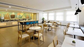 A modern dining area with a buffet, round tables, and chairs. - Hanting Hotel (Shanghai)