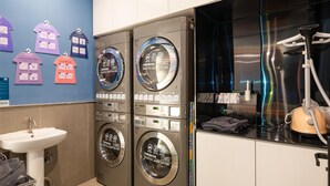 A laundry area with two front-loading washing machines, a sink, and a dryer. - Hanting Hotel Guangzhou Tianpingjia Metro Station (Guangzhou)