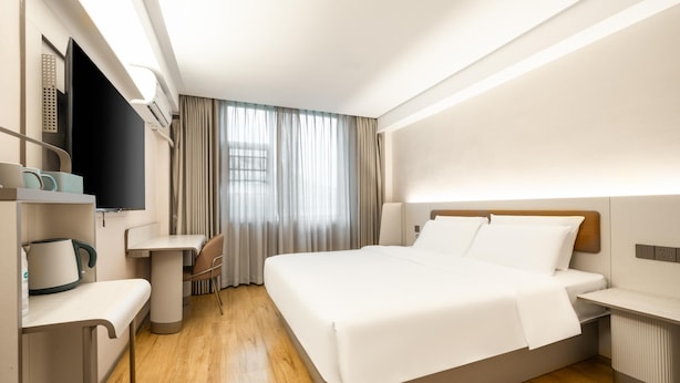 A hotel room with a bed, bedside tables, a desk, a chair, and a TV. - Hanting Hotel Guangzhou Tianpingjia Metro Station (Guangzhou)