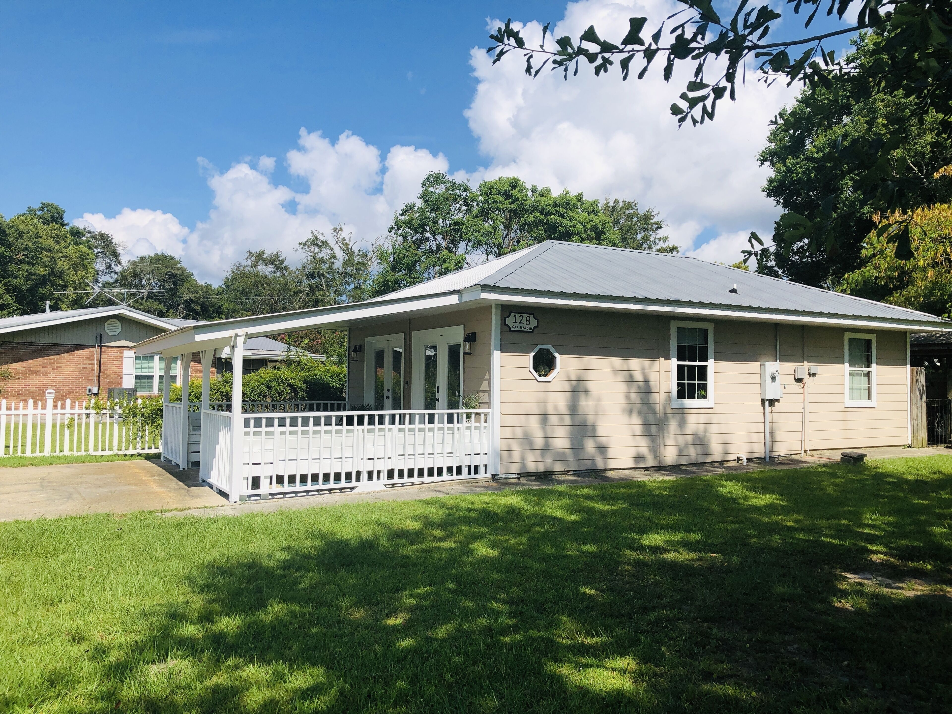 A single-story house with a covered porch, a front yard, and a brick garage.