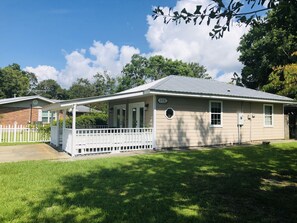 A single-story house with a covered porch, a front yard, and a brick garage.