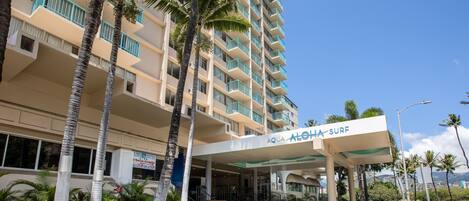 A hotel with a pool area, a sign for 'AQUA ALOHA SURF', and a 'LOHA BISTRO' restaurant.