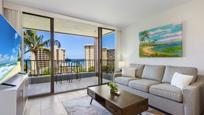 Un salon moderne avec un balcon donnant sur une plage et offrant une vue sur la ville.