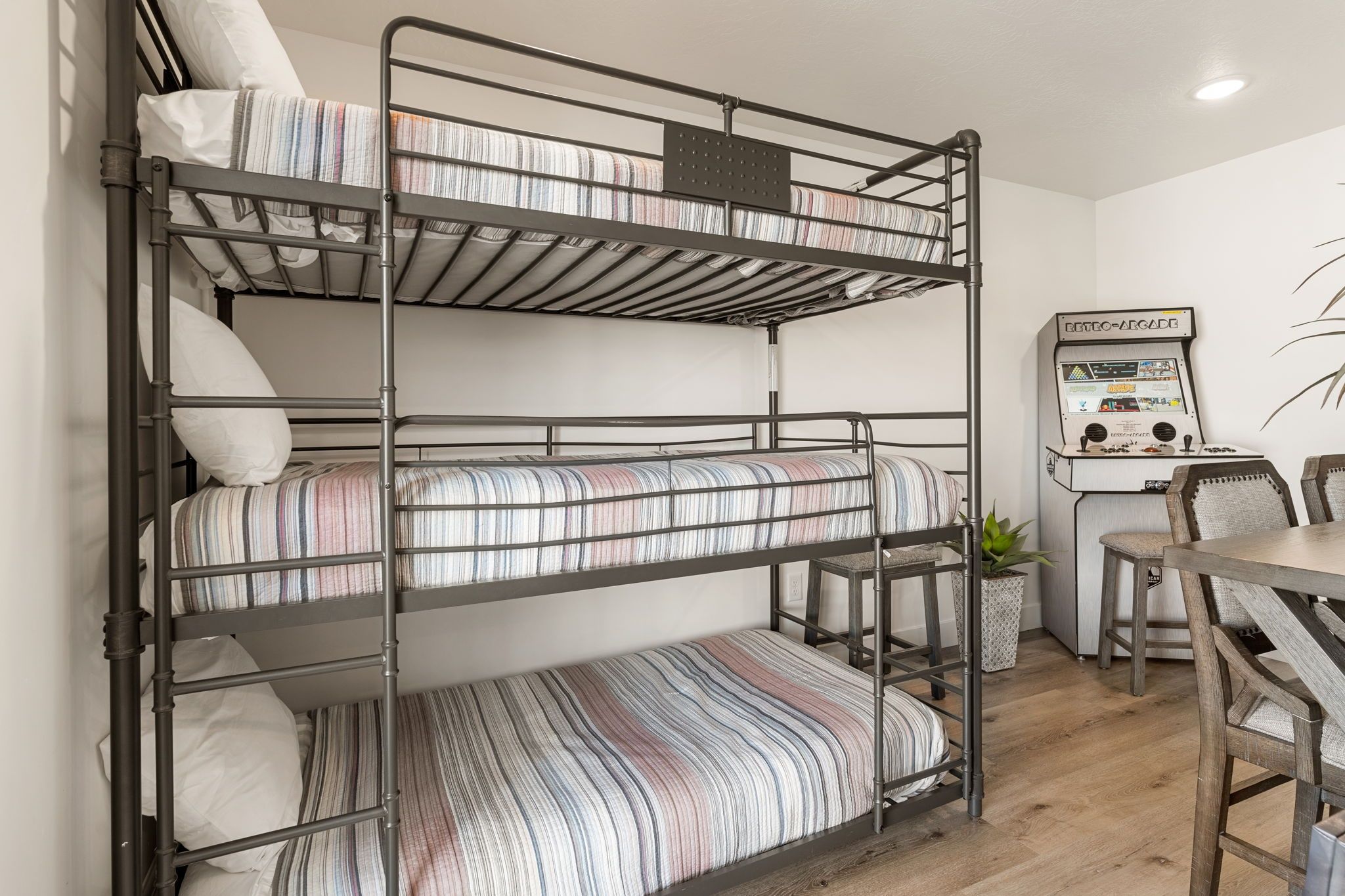 A bunk bed with a control panel and a table with chairs.