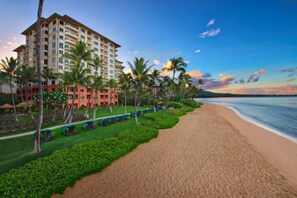 Ein Strandhotel mit Poolbereich, Palmen und Blick auf den Ozean.