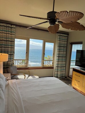A hotel room with a bed, a ceiling fan, a television, and a view of the ocean. - World Class Resort Marriott Maui Ocean Club Ground Floor Ocean Front 3 bd 3bth (Lahaina)