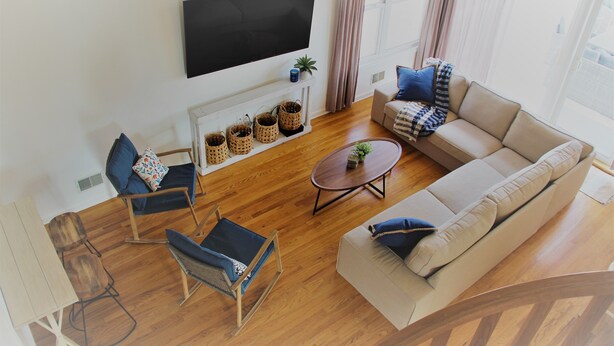 A modern living room with a sofa, chairs, a coffee table, and a TV mounted on the wall. - Newly Furnished Open Air Home, Steps to the Beach (Seaside Park)