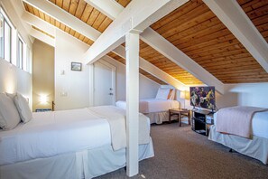 A room with two beds, a TV, and a ski-themed sign.