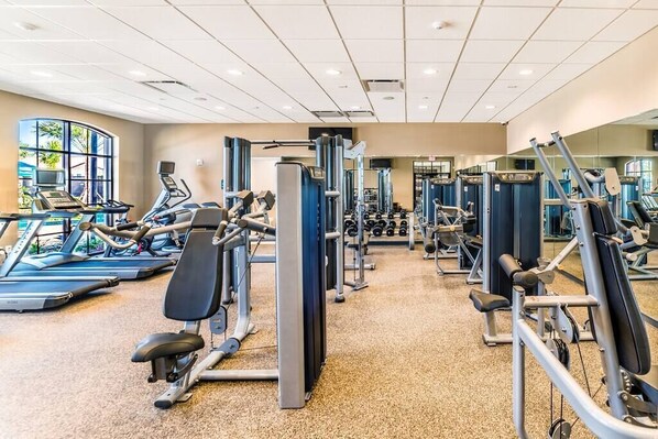 A gym with various exercise machines, treadmills, and weights. - BRAND NEW 🌟 BEAUTIFUL 2/2 CONDO W/LAKEVIEW 🎢 l (Osceola County)