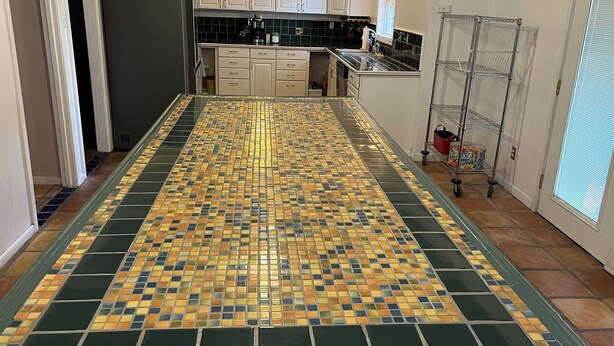 A kitchen with a large tiled backsplash, white cabinets, and a metal rack. - The Ranger House, 5 minutes to TAMU campus, quiet street, large fenced backyard (Bryan)
