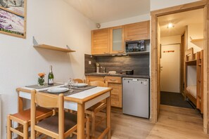 A compact kitchen with wooden cabinets, a microwave, and a small refrigerator. - Cham Sud Grepon102 Mountain-View Balcony for 4, Chamonix, France (Chamonix)
