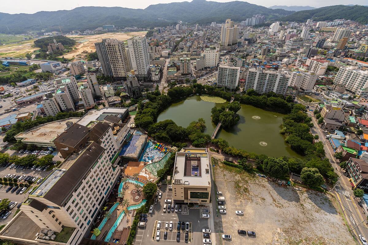 A high-rise urban area with a central pond surrounded by buildings.