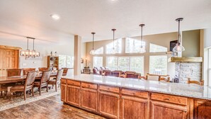A spacious kitchen with a large island, wooden cabinets, and pendant lighting. - Hot Tub & Forest Views - 3,650 Sq Ft, Two Living Rooms, Pet-Friendly, 26mi Breck (Fairplay)