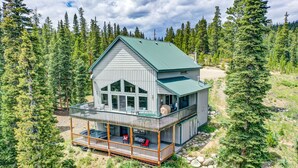 A two-story cabin with a balcony, surrounded by a forest. - Hot Tub & Forest Views - 3,650 Sq Ft, Two Living Rooms, Pet-Friendly, 26mi Breck (Fairplay)