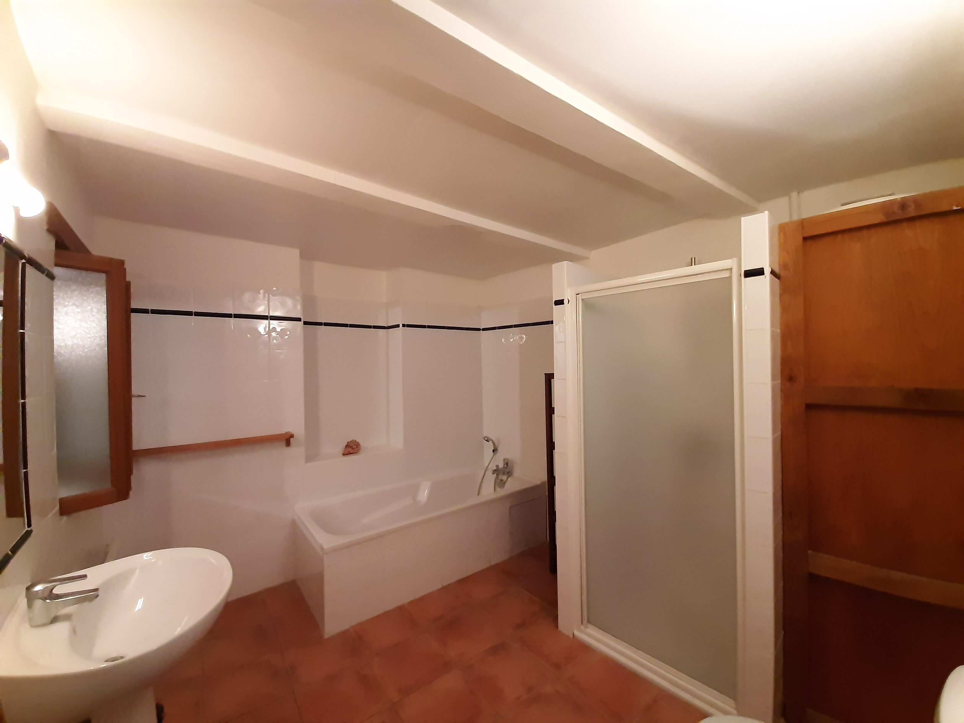 A bathroom with a sink, bathtub, and shower area.
