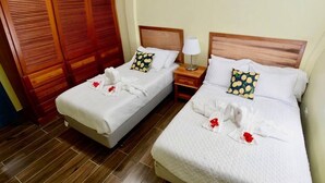 Two single beds with white linens, wooden headboards, and matching pillows.