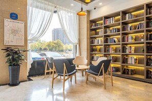A modern library with bookshelves, seating, and a view of the outdoors. - Geli Hotel (Shanghai Kangqiao Subway Station store, New International Expo Center ) (Shanghai)