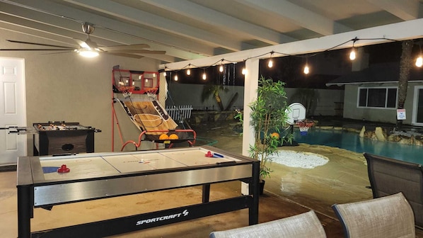 An indoor recreational area with a foosball table, a shuffleboard table, and a basketball hoop. - VeryPrivateHouse in Riverside,3bedrooms& 2 1/2 bathroom house w/Pool & big Patio (Riverside)