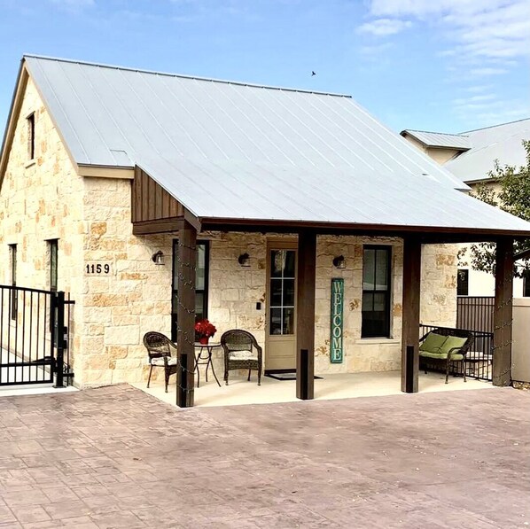 A stone building with a metal roof and a covered porch. - Gorgeous 2 bedroom Casita on the Guadalupe River walking distance from Gruene. (New Braunfels)