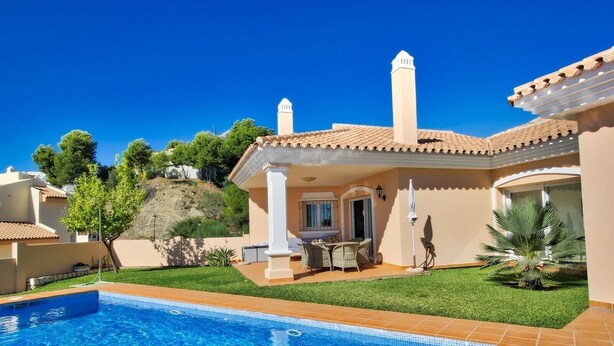 Um imóvel residencial com piscina, um pátio com mobiliário externo e um jardim.