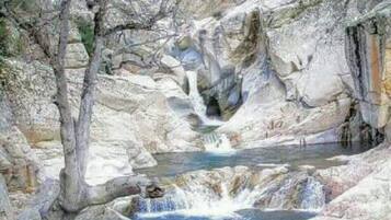Un paysage rocheux naturel avec une cascade et un bassin.