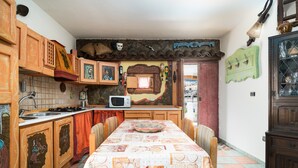 A kitchen with a dining table, cabinets, a microwave, and a tiled floor. - Holiday Home "Sa Burrida" with Garden, Covered Terrace & Fireplace (posada)