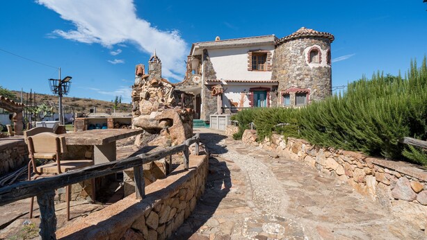 A stone building with a tower, a paved pathway, and a wooden fence. - Holiday Home "Sa Burrida" with Garden, Covered Terrace & Fireplace (posada)
