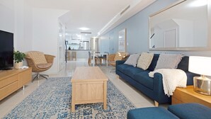 Un salon moderne avec un canapé, une table basse et un téléviseur.