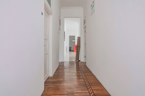 A hallway with wooden flooring and white walls. - Capital O 90342 Kemang Garden (Jakarta)