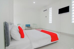 Une chambre d’hôtel équipée d’un lit, d’un bureau, d’une chaise, d’un téléviseur à écran plat et d’une fenêtre.