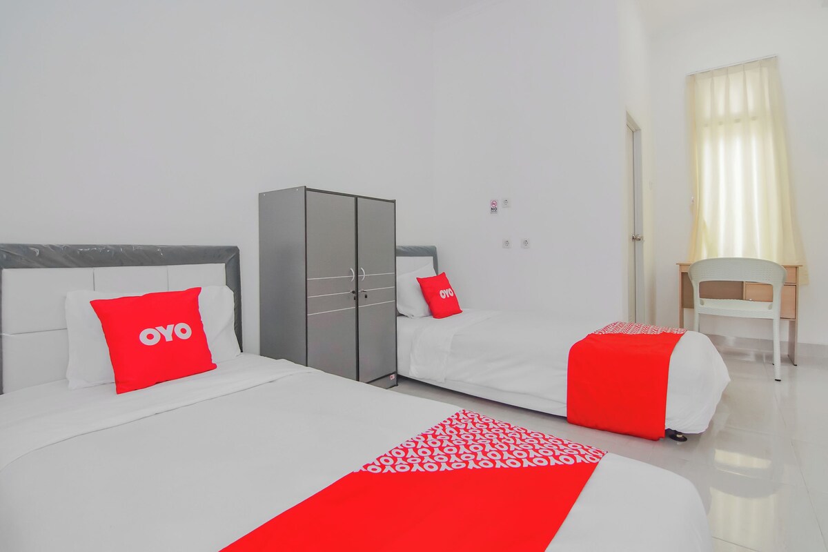 Habitación de hotel con una cama grande, un armario, un escritorio y una silla.