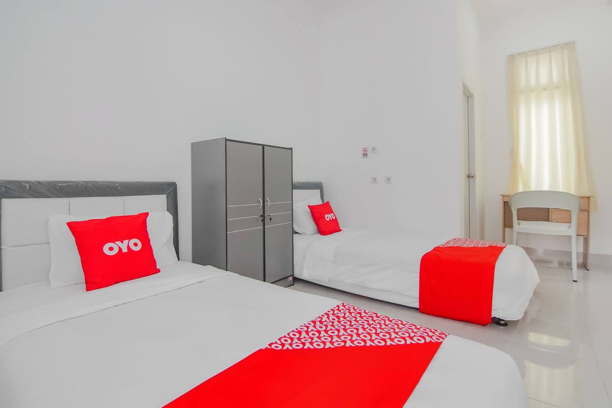 Une chambre d’hôtel avec un grand lit, une armoire, un bureau et une chaise.